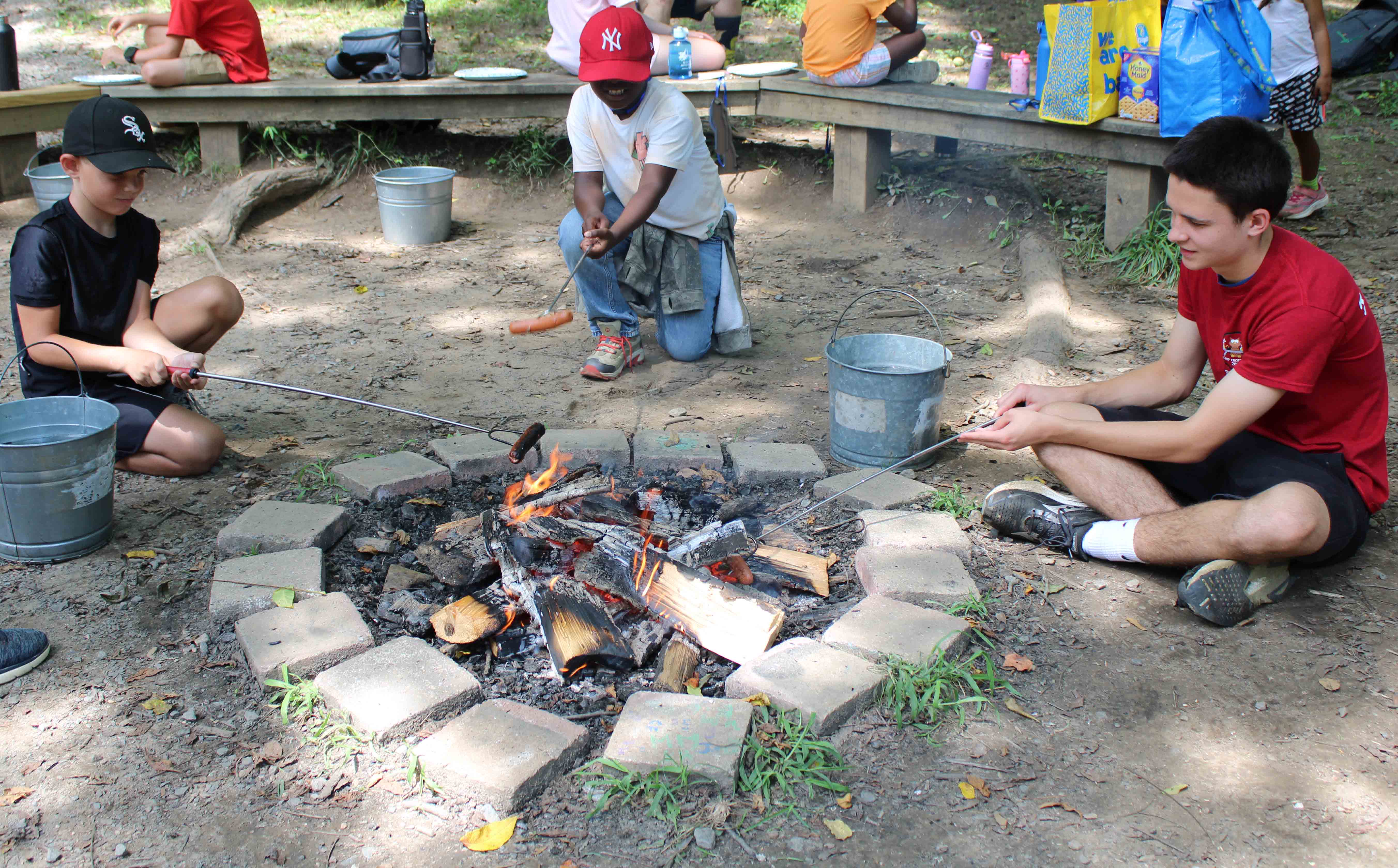 A camper diligently threading beads during a beading craft station.