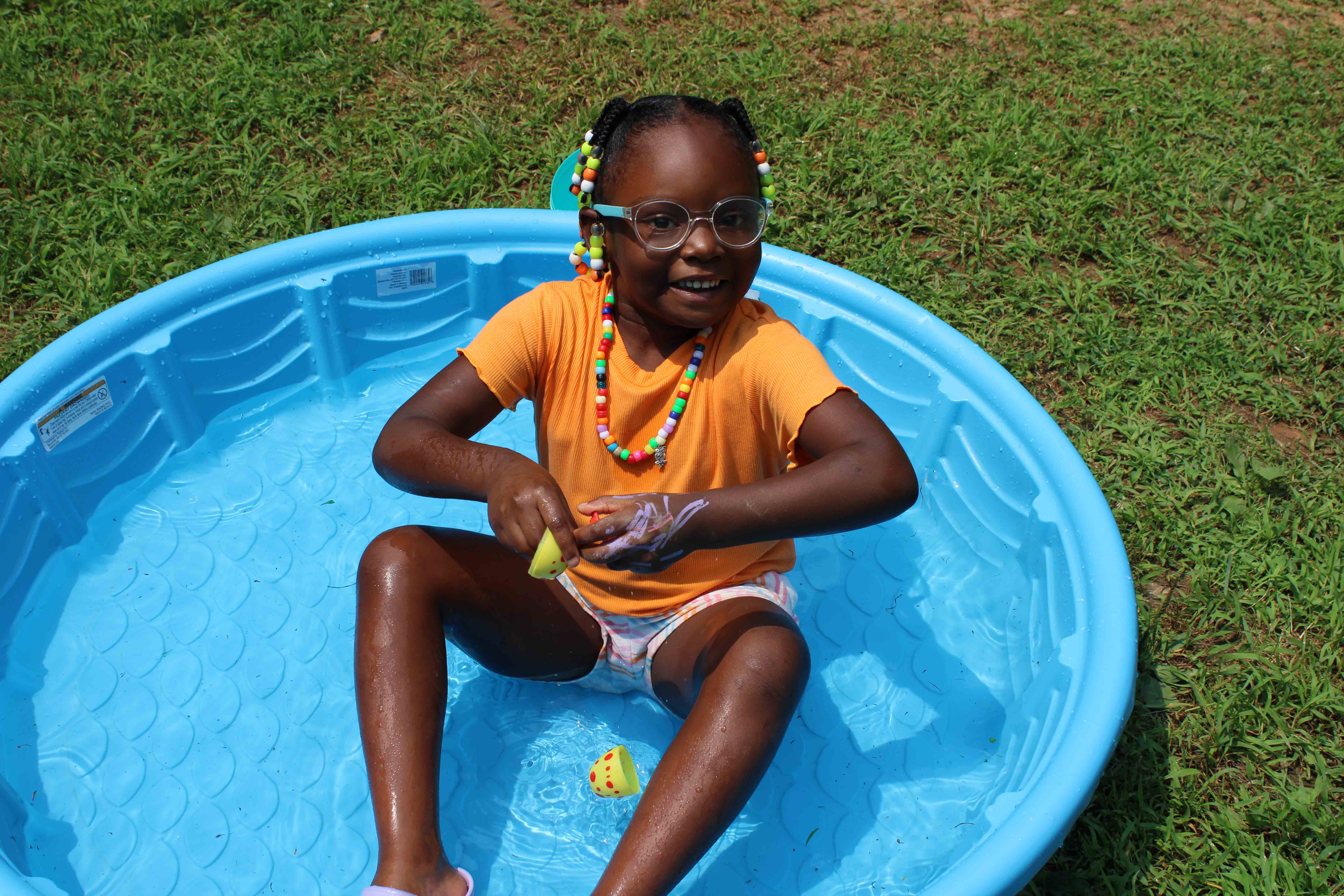 A happy camper presenting a newly finished, brightly colored tie-dye craft.